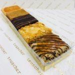 A tray of different types of pastries on top of a table.