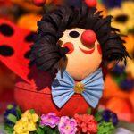 A close up of a clown figurine on top of flowers.