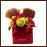 A red box with flowers and feathers in it