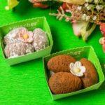 Two boxes of cookies on a green table.