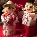 A couple of paper mache dolls are standing on the table