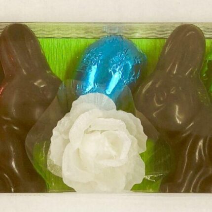 A close up of three chocolate bunnies with a white rose