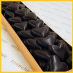 A close up of chocolate hearts in a box