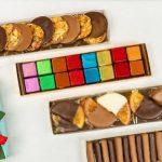 A variety of cookies are arranged in boxes.