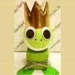 A green frog with a gold crown on its head.