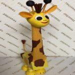 A giraffe statue sitting on top of a wall.