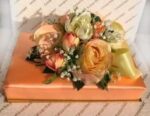 A bouquet of flowers on top of an orange box.