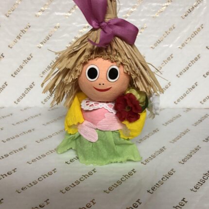 A doll with long hair and a purple bow on it's head.