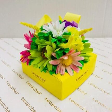 A yellow box with flowers on top of it.