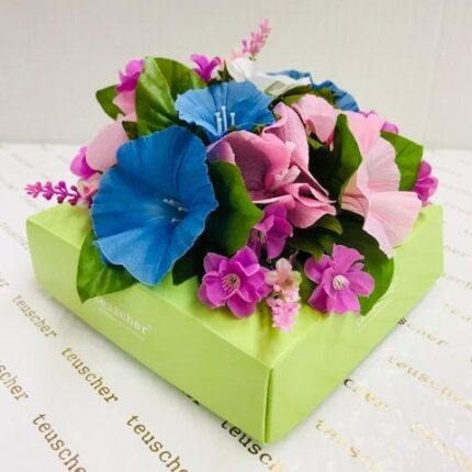 A green box with flowers on top of it.