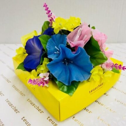 A yellow box with flowers on top of it.