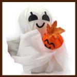 A white ghost holding an orange pumpkin.