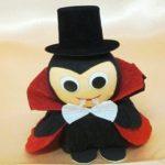 A small stuffed toy of dracula wearing a top hat.