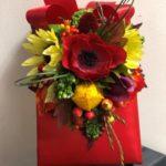 A red bag with flowers on top of it.