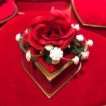 A red velvet table cloth with flowers on top of it.