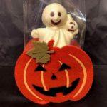 A small ghost sitting in the middle of a pumpkin.