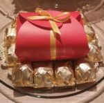 A plate with wrapped chocolates and a red box.