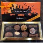 A box of halloween chocolates with a bow on top.