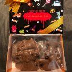 A box of chocolate treats with bat and pumpkin designs.
