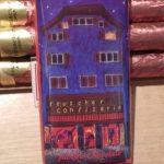 A blue building with a red roof and a purple sky.