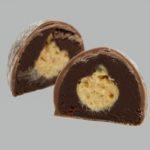 A chocolate covered dessert with peanut butter inside.