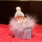 A baby doll sitting on top of a box.