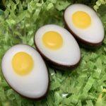 Three eggs are sitting on a green grass.