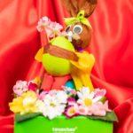 A bunny rabbit with flowers and a tennis ball.