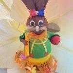 A close up of a toy rabbit with flowers