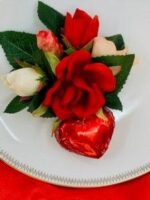 A plate with roses and chocolate heart on it