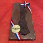 A chocolate statue of liberty is wrapped in ribbon.