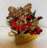 A gold butterfly with red berries and green leaves.