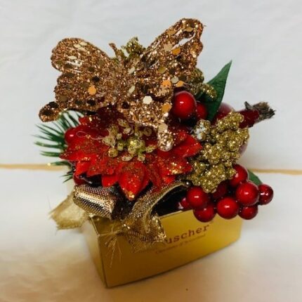 A gold butterfly with red berries and green leaves.