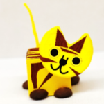 A cat made out of paper sitting on top of a table.