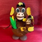 A monkey with a baby monkey in its mouth.