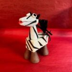 A zebra figurine sitting on top of a red table.